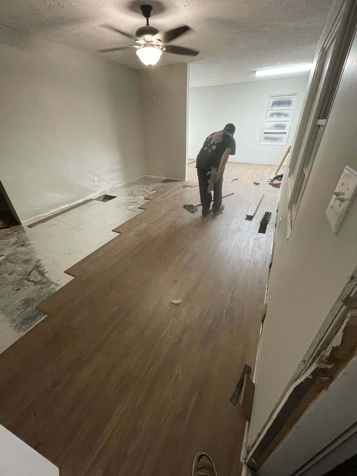 Luxury vinyl plank flooring being installed across a living room