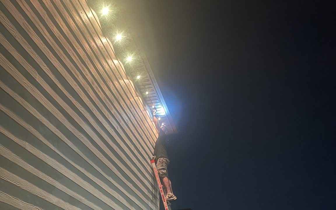 Wright Way Services technician installing exterior lighting after hours